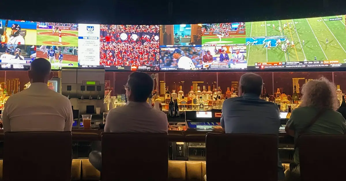People at a bar watching sport on several screens