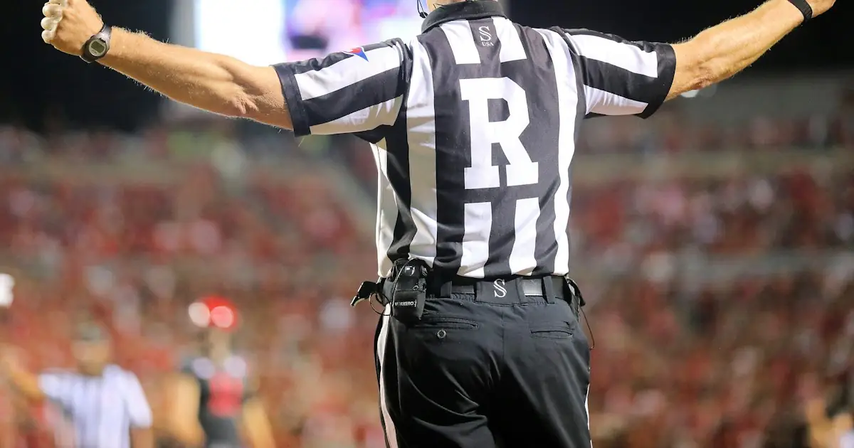 A referee signalling with both arms raised