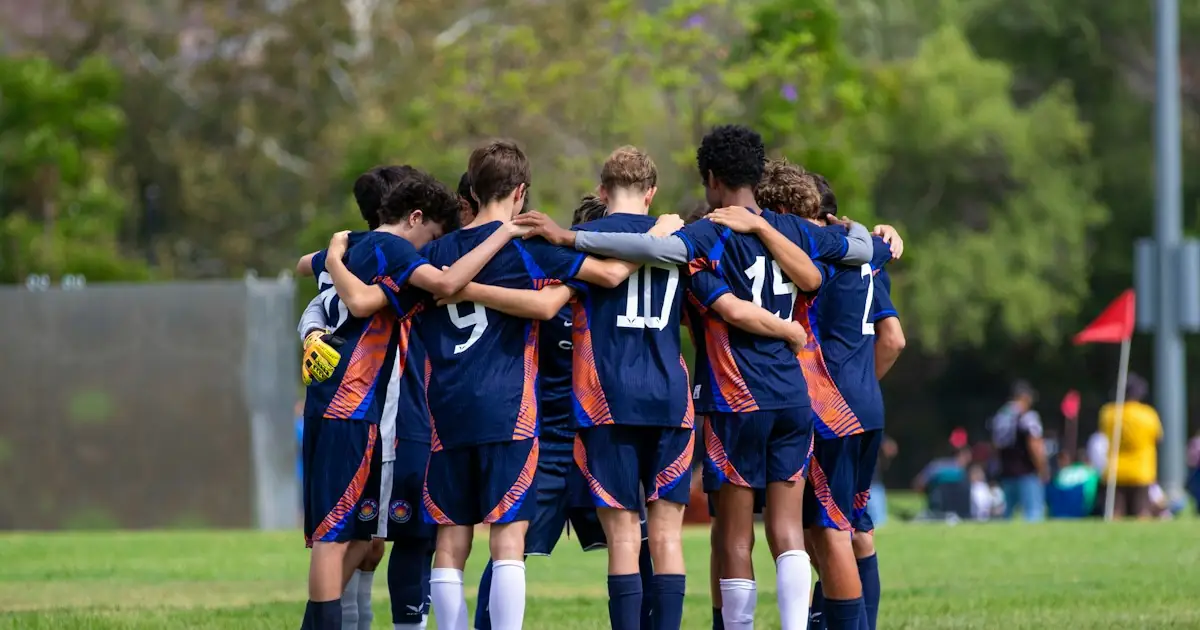 A youth football team in a huddle before kick-off